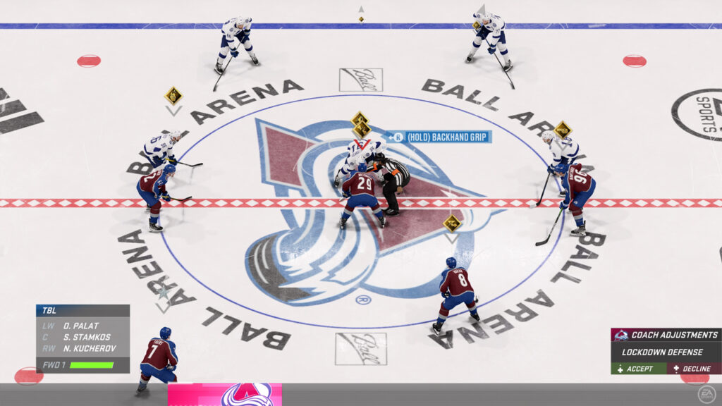 A face-off in NHL 23 with the Coaching Suggestion at the bottom right of the screen